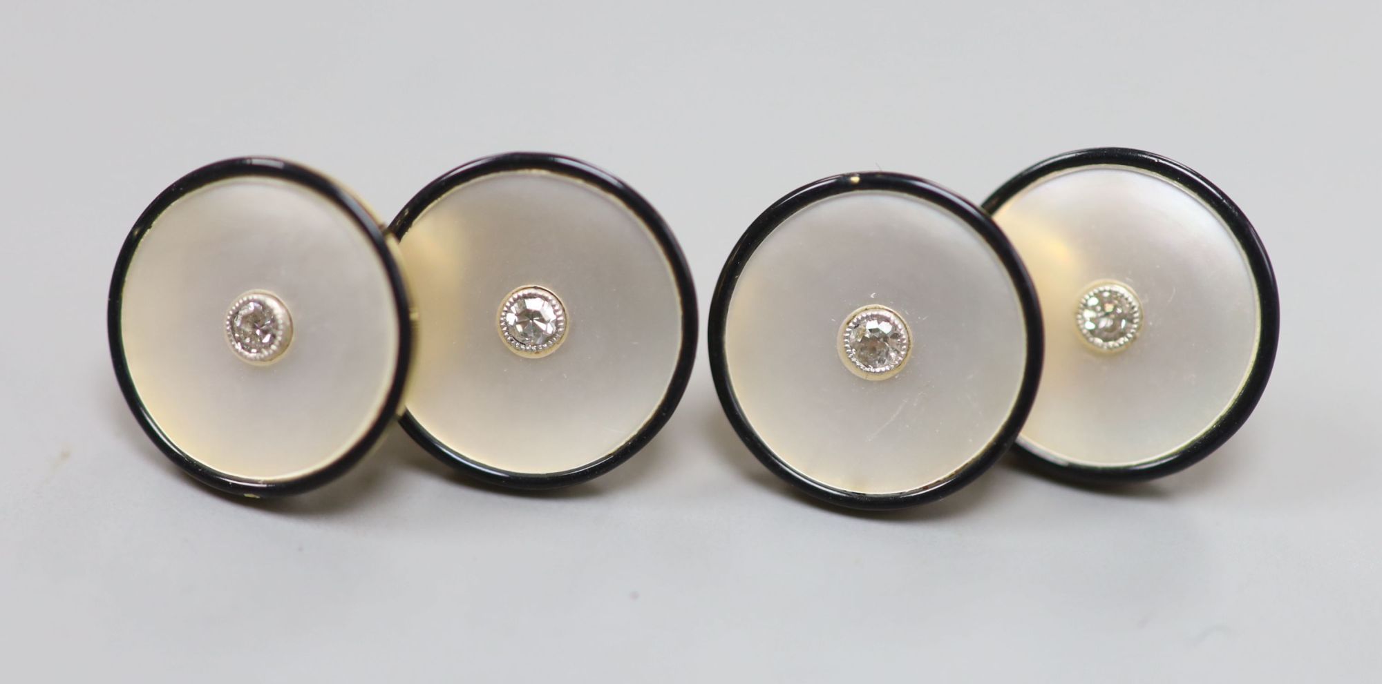 A pair of yellow metal (stamped 18), mother of pearl , black enamel and diamond set cufflinks, 12mm, gross 7.7 grams.